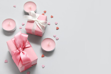 Pink gift boxes, hearts and candles on grey background. Valentine's Day celebration
