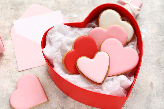 Box with heart-shaped cookies on grey grunge background, closeup. Valentine's Day celebration