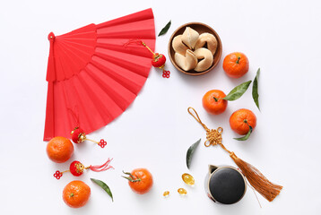 Frame made from paper fan, tangerines and Chinese symbols on white background. New Year celebration