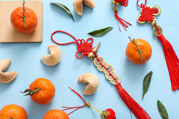 Composition with  tangerines, fortune cookies and Chinese symbols on blue background. New Year...