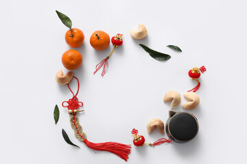 Frame made from tangerines, fortune cookies and Chinese symbols on white background. New Year...