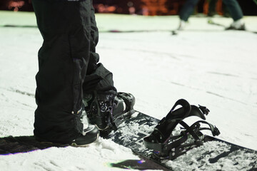 No-face feet of night snowboarders on a winter night.