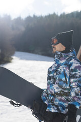Man preparing to snowboard on the slopes Close-up profile Vertical