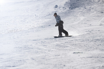 Fototapeta na wymiar Wide angle of a man snowboarding in a snowfield