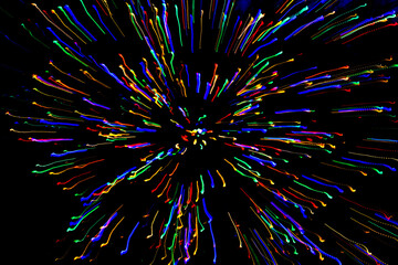 Long exposure light trails of colorful holiday lights in an exploding pattern on a dark background...