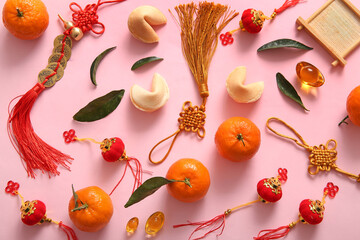 Composition with tangerines and different Chinese symbols on pink background. New Year celebration