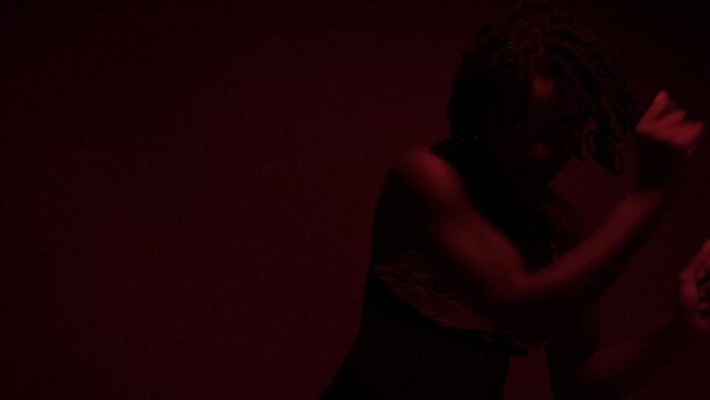 Slow motion of black woman solo dance performance under red lights