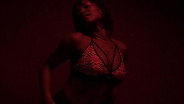 Slow motion shot of black woman dancing dancehall under neon lights