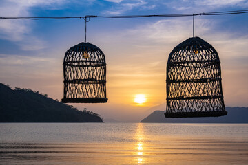 lantern made of wicker basket. sunrise over the sea in the background.