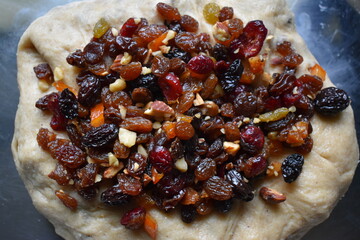 Dried fruit mix and nut soaked in rum on rolled bread dough. Stollen preparation.