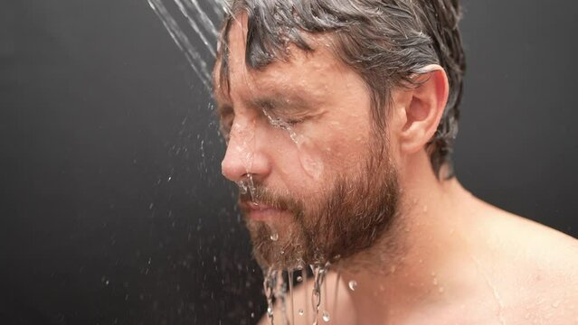 Man washing hair, close up portrait. Man bathing shower washing hair head in bathroom. Male model washing hair in shower. Sexy man taking shower. Guy showering. Male shampoo and washing hair concept.