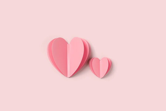 Two Pink paper hearts on pink colored background. Minimal style flat lay, pastel monochrome colors, valentine card or wedding invitation. Paper cut romantic concept, big ans small hearts