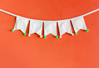 White fabric bunting flag on orange texture background, party and celebration background idea,...