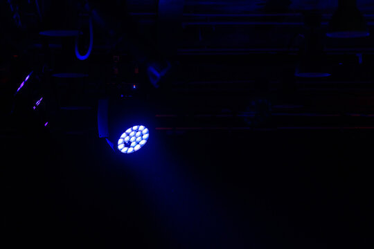 Stage LED spot light with blue beam in the dark