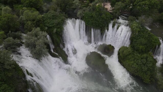 View from above of water flowing through trees at the Kravica waterfall in Bosnia, the image created by the rapid flow of water