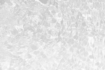 White water with ripples on the surface. Defocus blurred transparent white colored clear calm water surface texture with splashes and bubbles. Water waves with shining pattern texture background.