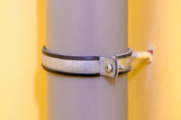 Sewer pipe in home against the background of a yellow wall in the toilet. Connection of grey...