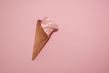 Gift box in an ice cream cone on a pink background. Flat lay.