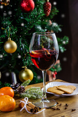 christmas still life mulled red wine on the wooden table with christmas tree, copy space vertical
