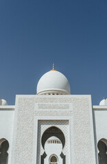 Fototapeta na wymiar view of Sheikh Zayed Grand Mosque with minimalist several domes over clear blue sky in uae
