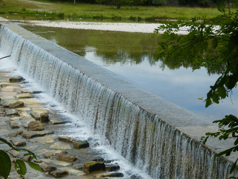 small waterfall with water of the wide river without people in the valley
