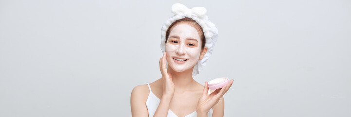 Beautiful Asian woman with facial mask on color banner background - 698460938