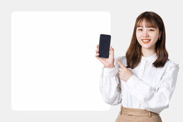 スマホを指差して案内をする笑顔の女性_背景白枠スペース付き