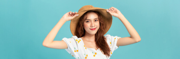 beautiful attractive stylish woman in straw hat posing on blue background