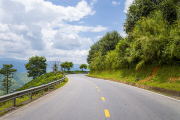 An asphalt road in the middle of the countryside and mountains, in Asia, Vietnam, Tonkin, between Son La and Dien Bien Phu, in summer, on a sunny day.