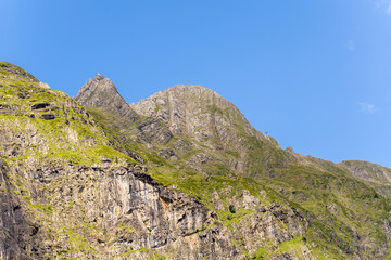 The barren rocky mountains in the middle of the countryside , Europe, France, Occitanie, Hautes-Pyrenees, in summer on a sunny day.
