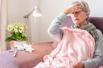 Older adult caucasian woman with severe cold and fever symptoms such as seasonal flu or covid -...