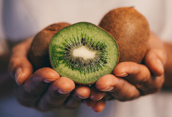 Closeup on woman hands holding group of ripe green kiwi fruits. Healthy fruits concept.
