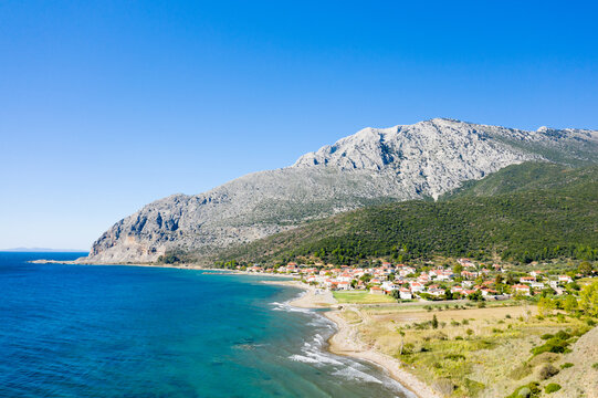 The town on the rocky coast in the middle of green countryside , Europe, Greece, Aetolia Acarnania, Kato Vasiliki towards Patras, by the Ionian Sea, in summer on a sunny day.