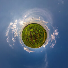 green tiny planet in evening blue sky with beautiful clouds. Transformation of spherical panorama...
