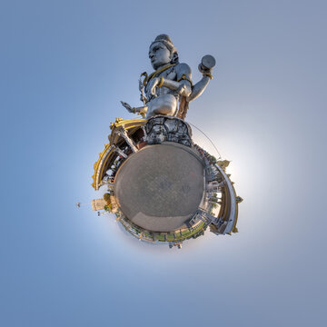 tallest hindu shiva statue in india on mountain near ocean on little planet in blue sky, transformation of spherical 360 panorama. Spherical abstract view with curvature of space.