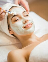 Woman receiving a Facial Clay Mask in Wellness Resort or Spa - Relaxation and Skin Care done by Beautician