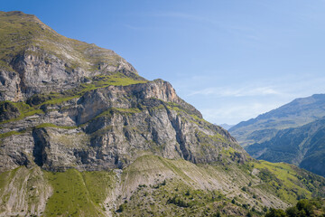 The Mountains around Gavarnie Gedre in the arid green countryside , Europe, France, Occitanie, Hautes-Pyrenees, in summer on a sunny day.