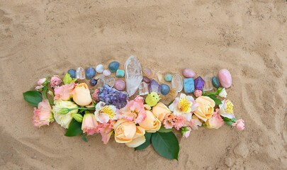 Fototapeta na wymiar different colorful minerals, flowers on sand background. Handmade floral arrangement, mandala, nature offering. Crystal Ritual, Esoteric spiritual practice for relax, harmony, life balance. top view