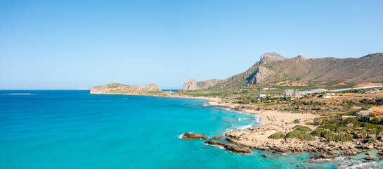 The sandy beach at the foot of the rocky cliffs in the arid countryside , in Europe, Greece, Crete,...