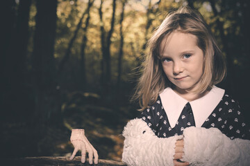 Young girl in halloween style posing in autumn forest