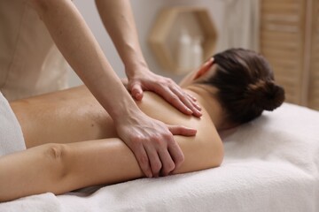 Obraz premium Woman receiving back massage on couch in spa salon