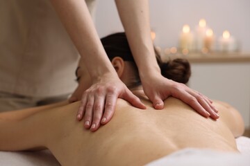 Obraz na płótnie Canvas Woman receiving back massage in spa salon, focus on hands