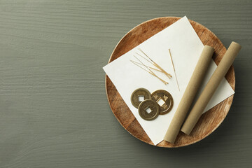 Acupuncture needles, moxa sticks and antique Chinese coins on grey wooden table, top view. Space...
