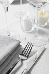 Beautiful table setting with silverware and candles, closeup