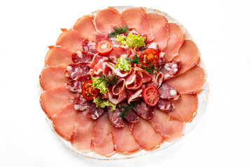 Salami, sausage and Parma ham sliced on plate isolated on white