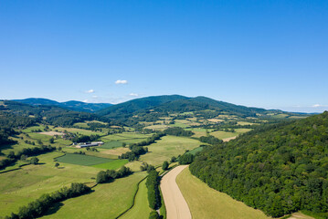 The countryside with its forests and green fields in Europe, France, Burgundy, Nievre, towards Chateau Chinon, in summer, on a sunny day.