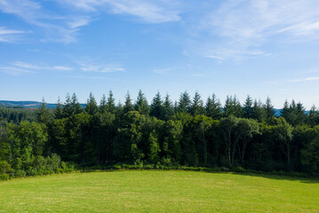 Fototapeta premium The countryside with its forests and green fields in Europe, France, Burgundy, Nievre, towards Chateau Chinon, in summer, on a sunny day.