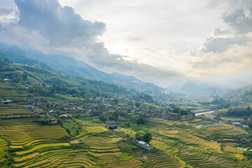 The traditional village with green and yellow rice fields in the green mountains, Asia, Vietnam,...
