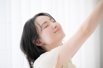 Closeup of woman waking up from sleep or taking a deep breath in the morning Cute smile Close eyes