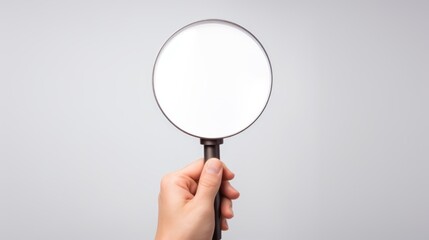  a person's hand holding a magnifying glass with a white blank space in the middle of it. - obrazy, fototapety, plakaty